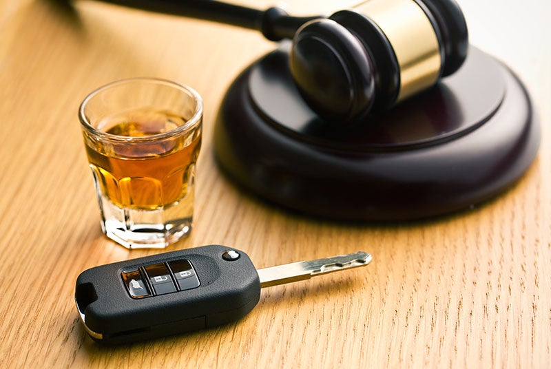 image of a shot of liquor, a gavel and a car key